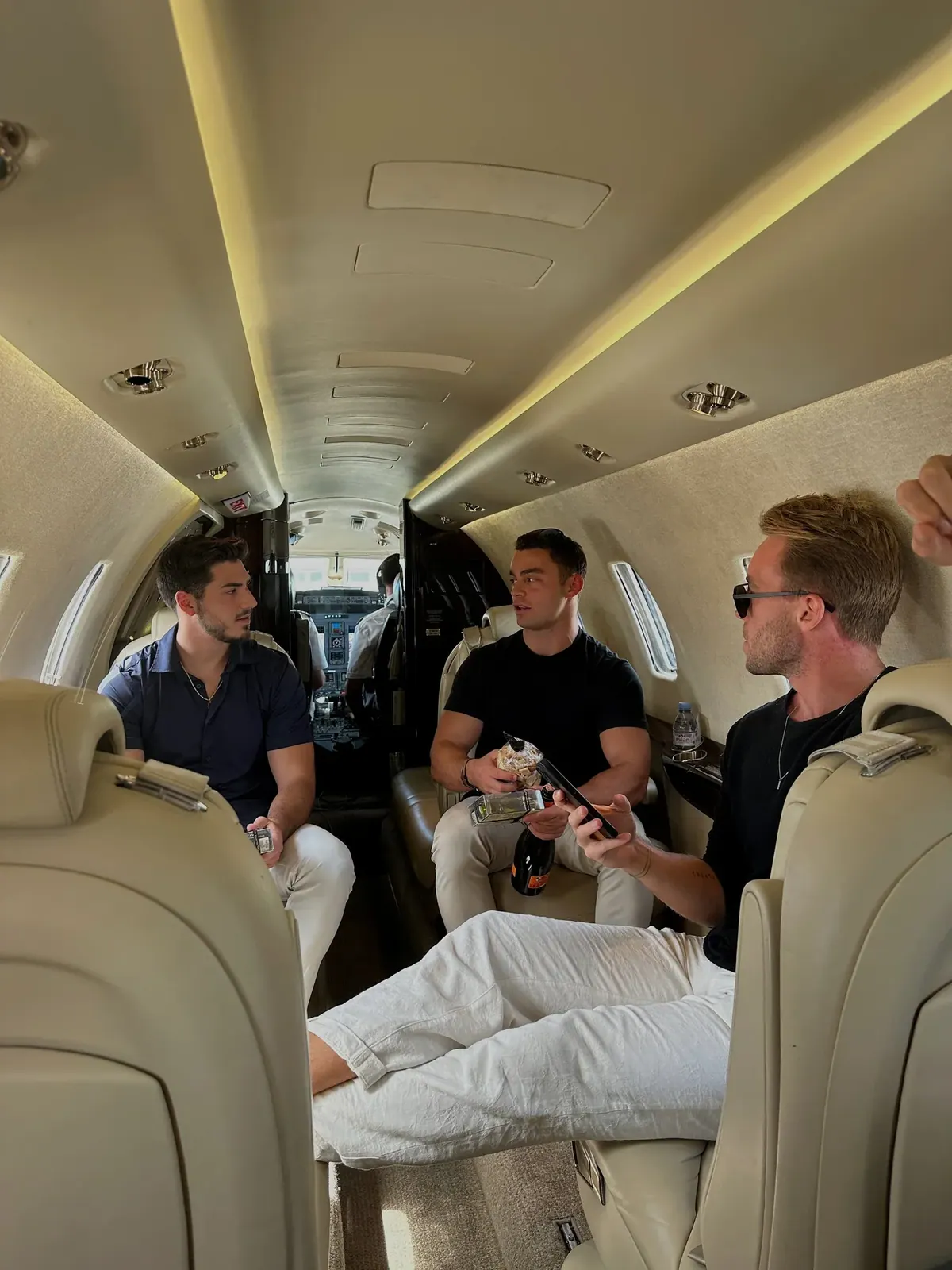 Members in a private jet cabin, champagne