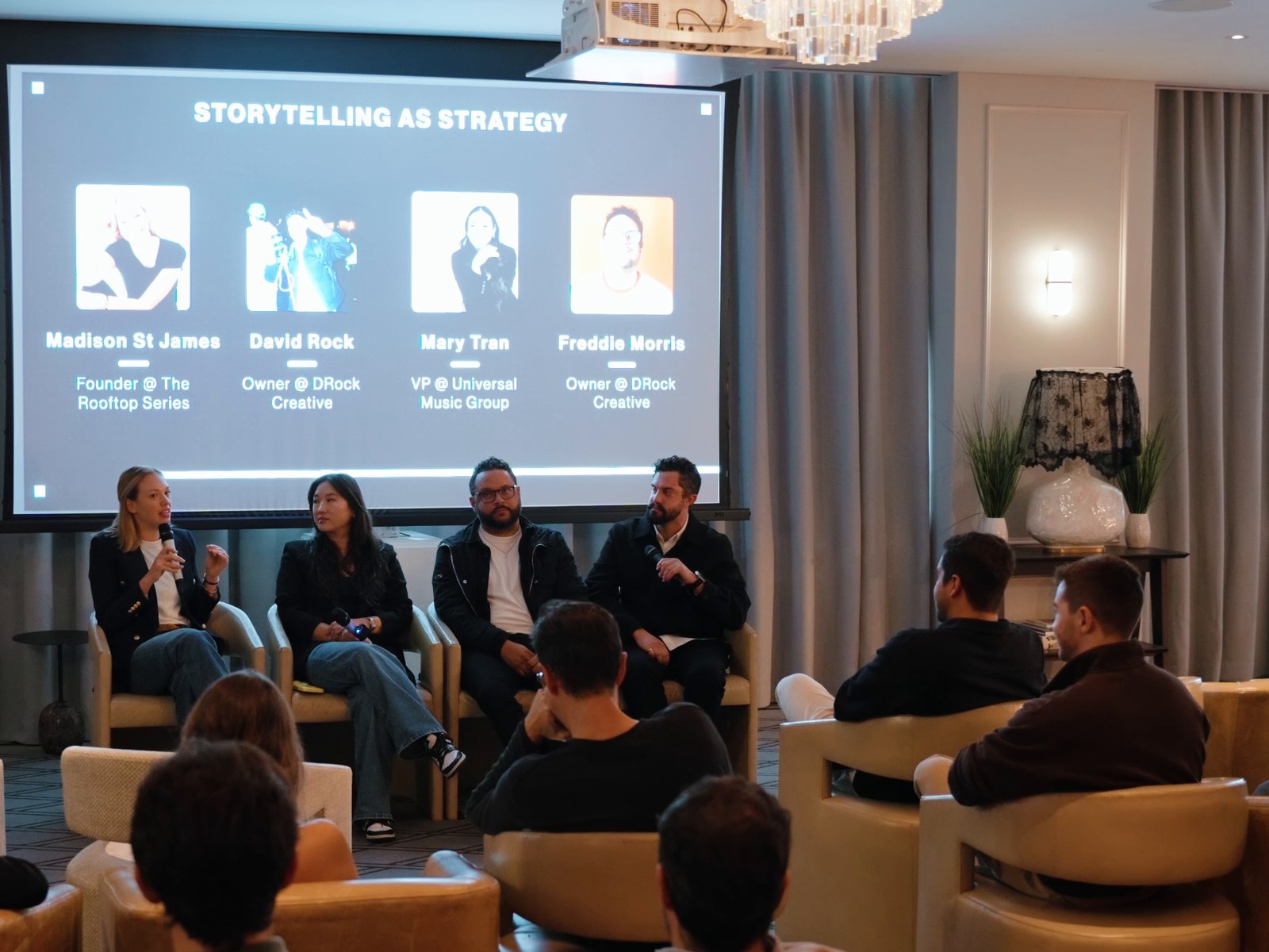 A panel on stage before a seated audience